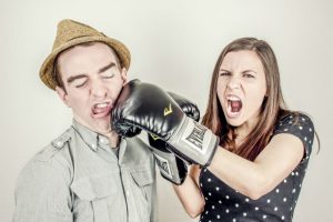 Imagen de una mujer golpeando a un hombre con un guante de boxeo